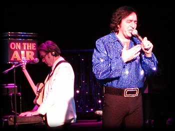 Richi Harris on guitar AND keyboards behind Tom here as he gets the audience to join in on SWEET CAROLINE
